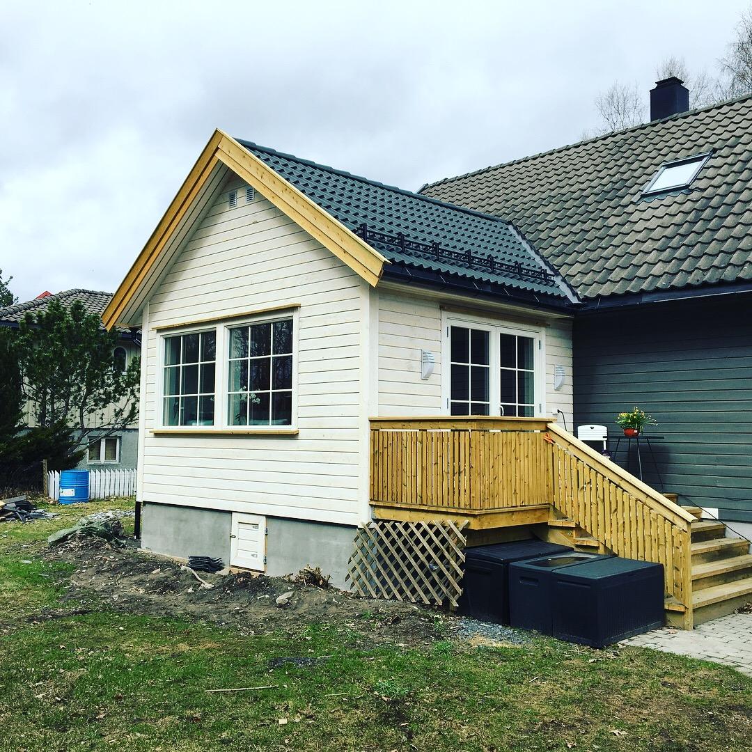 A small house with a new wooden stair and deck