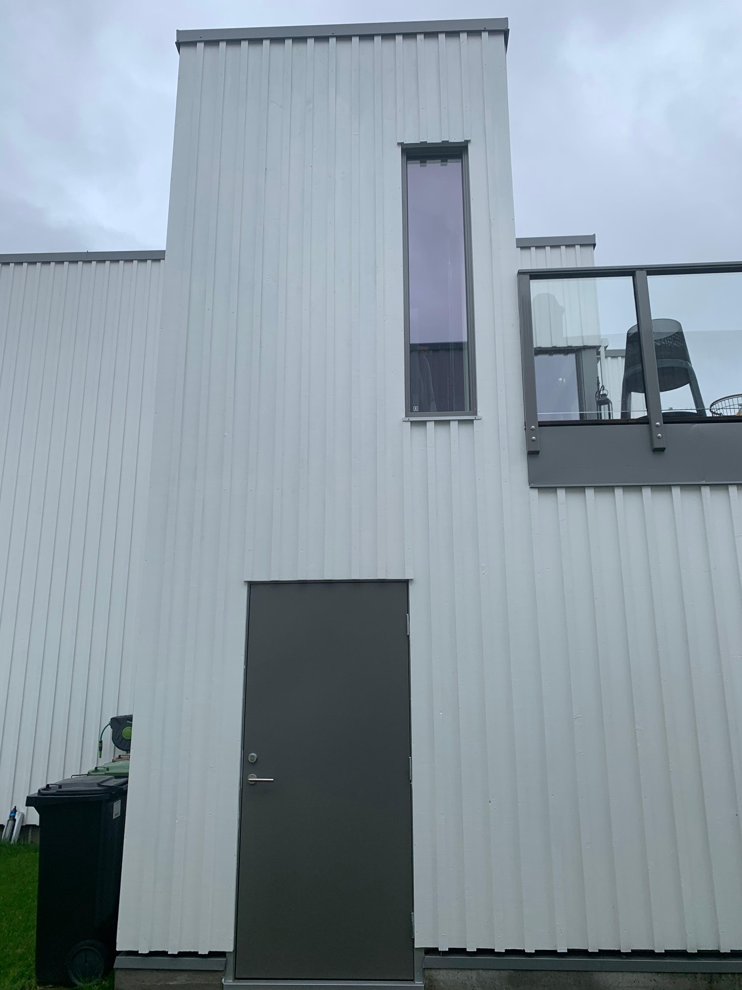 Fresh white vertical cladding on a tall narrow building